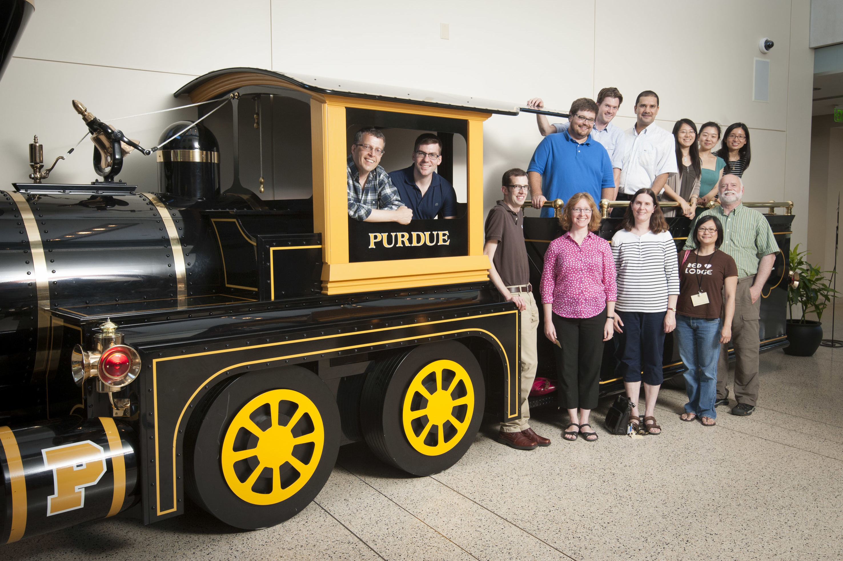 People standing next to a large model train