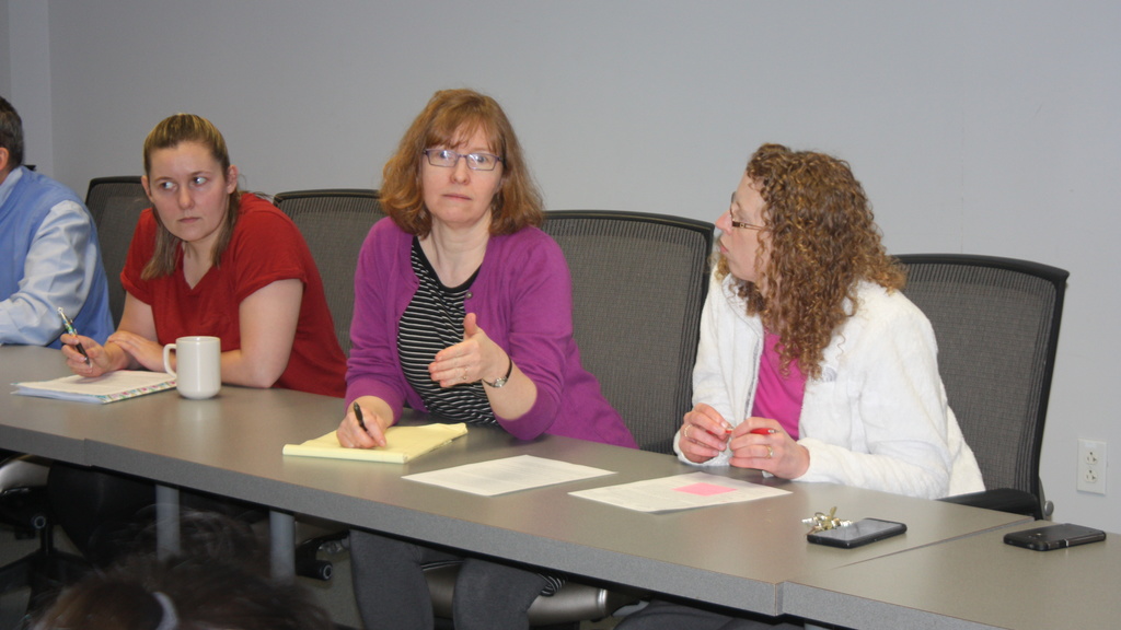 Three faculty sitting at a table discussing items