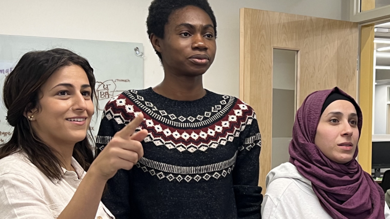 Three students looking towards something - one is pointing